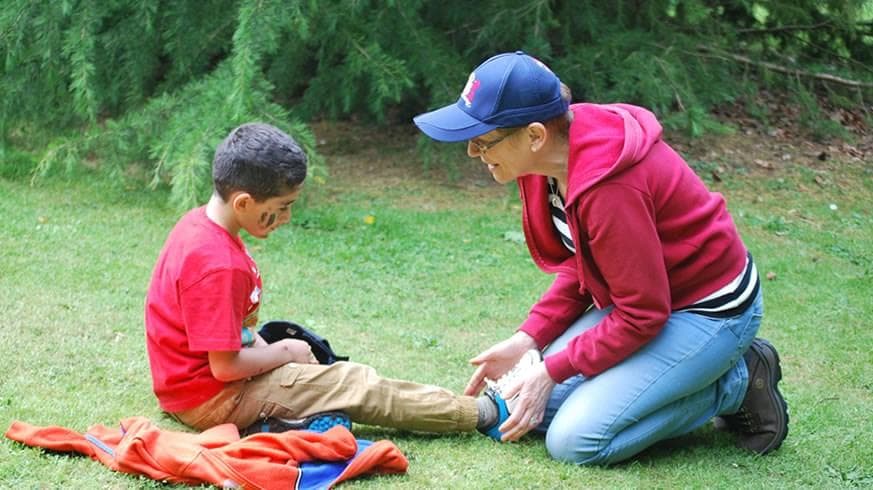 Adult leaning over child asking if they are ok